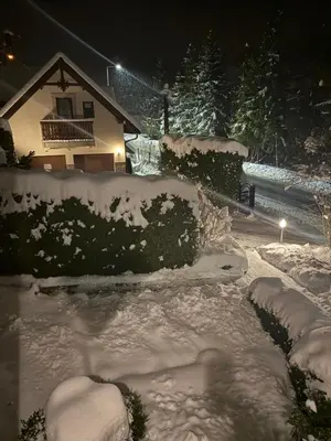 a yard covered in snow in front of a house at Domek pod Maciejową in Rabka