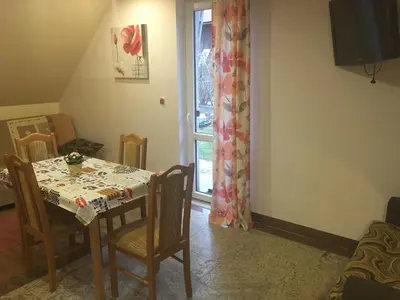 a dining room with a table and chairs and a window at Domek pod Maciejową in Rabka