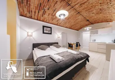 a bedroom with a large bed with a wooden ceiling at M1 Main Square Studio in Kraków