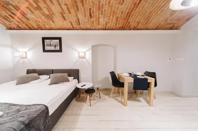 a bedroom with a bed and a table and chairs at M1 Main Square Studio in Kraków