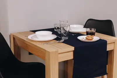a wooden table with plates and glasses on it at M1 Main Square Studio in Kraków