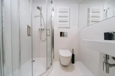 a white bathroom with a shower and a toilet at M1 Main Square Studio in Kraków