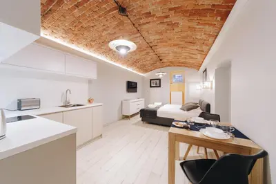 a kitchen and living room with a room with a bed at M1 Main Square Studio in Kraków