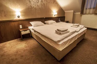 a bedroom with a large bed with towels on it at Hotel Tatarscy - ENERGYLANDIA in Kalwaria Zebrzydowska