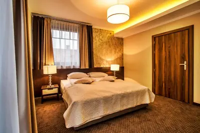 a bedroom with a bed and two lamps and a window at Hotel Tatarscy - ENERGYLANDIA in Kalwaria Zebrzydowska