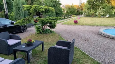 a yard with chairs and a table and a car at Pokoje Gościnne U Ewy in Wieliczka