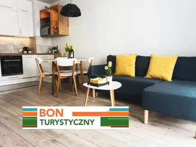 a living room with a blue couch and a table at Nowe Zabłocie II in Kraków
