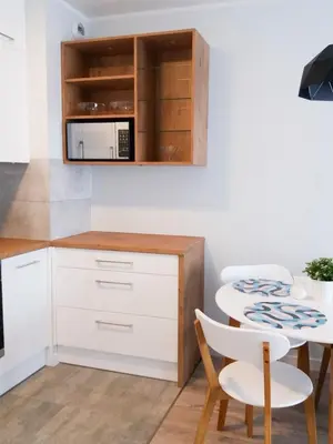 a small kitchen with a table and a microwave at Nowe Zabłocie II in Kraków