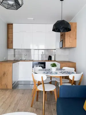 a kitchen and dining room with a table and chairs at Nowe Zabłocie II in Kraków
