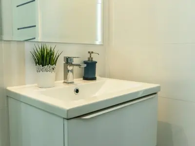 a bathroom with a white sink and a mirror at Nowe Zabłocie II in Kraków