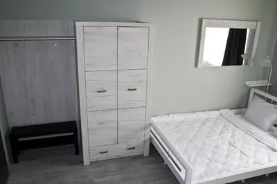 a bedroom with a white dresser and a bed at Motel Lunar in Oświęcim