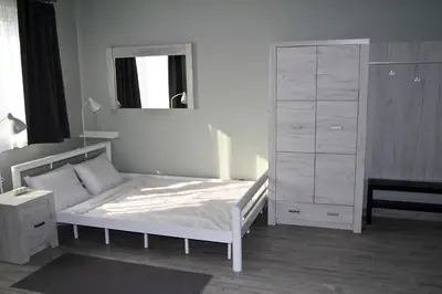 a bedroom with a white bed and a dresser at Motel Lunar in Oświęcim