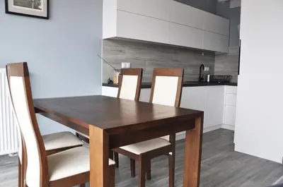 a kitchen with a wooden table and chairs at Kościuszki 28 A by Homeprime in Kraków