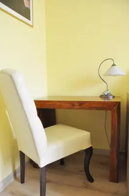a desk with a white chair and a lamp at Kościuszki 28 A by Homeprime in Kraków