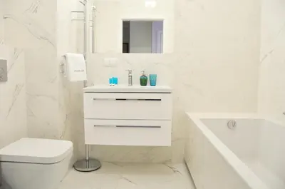 a white bathroom with a sink and a toilet at Kościuszki 28 A by Homeprime in Kraków