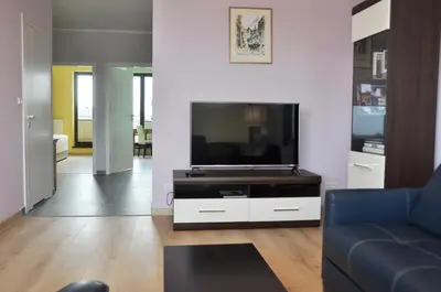 a living room with a tv and a blue couch at Kościuszki 28 A by Homeprime in Kraków
