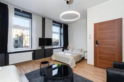 a living room with a bed and a tv at Rainbow Apartments 1 in Kraków