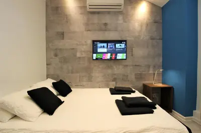 a bedroom with a bed with a tv on the wall at Rainbow Apartments 1 in Kraków