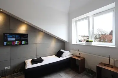 a room with a couch in the corner with a window at Rainbow Apartments 1 in Kraków