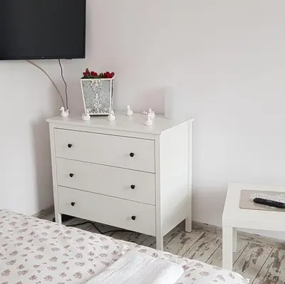 a white dresser with a tv on top of it at Apartament Bernadett in Oświęcim