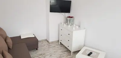 a living room with a couch and a tv on a dresser at Apartament Bernadett in Oświęcim