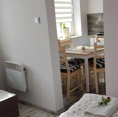 a kitchen and dining room with a table and chairs at Apartament Bernadett in Oświęcim