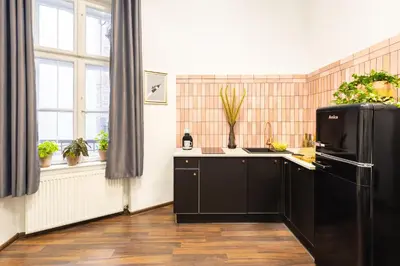 a kitchen with a black refrigerator and some windows at Das Hostel in Kraków