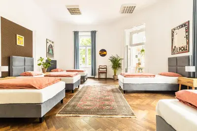 a room with four beds and a rug at Das Hostel in Kraków