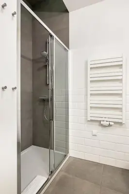 a shower with a glass door in a bathroom at Relaks Apartamenty in Kraków