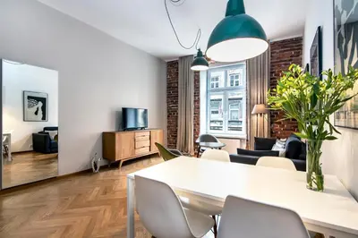 a living room with a dining room table and chairs at Relaks Apartamenty in Kraków