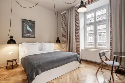 a bedroom with a bed and a table and a chair at Relaks Apartamenty in Kraków