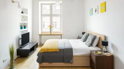 a bedroom with a bed and a television in it at City View Apartments in Kraków