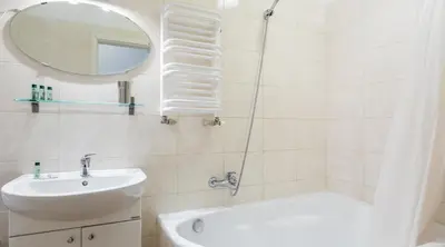 a bathroom with a sink and a tub and a mirror at City View Apartments in Kraków