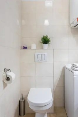 a white bathroom with a toilet and a sink at City View Apartments in Kraków
