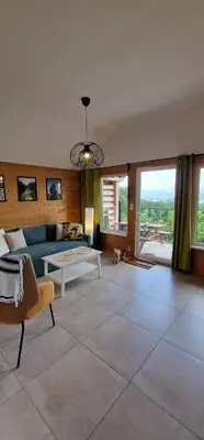 a living room with a couch and two pictures on the wall at Podbucznik 1 Pilsko in Targoszów