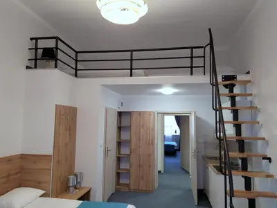 a bedroom with a bunk bed and a spiral staircase at Villa Centro in Oświęcim