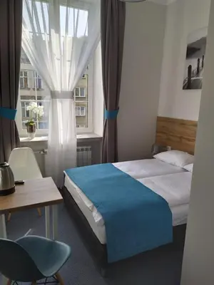 a bedroom with a bed and a desk and a window at Villa Centro in Oświęcim