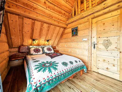 a bedroom with a bed in a wooden cabin at Jarogówka Stylowy dom góralski in Obidowa