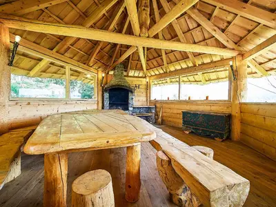 a wooden table and bench in a cabin with a fireplace at Jarogówka Stylowy dom góralski in Obidowa