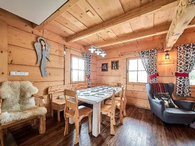 a dining room with a table and chairs at Jarogówka Stylowy dom góralski in Obidowa