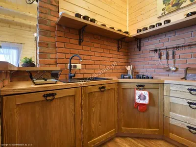 a kitchen with wooden cabinets and a sink at Stodoła Simonka na punkcie widokowym in Zawoja