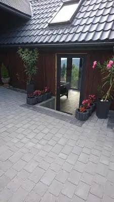 a patio with potted plants and a house at Stodoła Simonka na punkcie widokowym in Zawoja