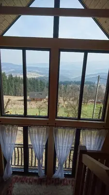 a large window with white curtains in a room at Stodoła Simonka na punkcie widokowym in Zawoja