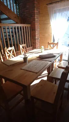 a wooden table and chairs in a room at Stodoła Simonka na punkcie widokowym in Zawoja