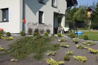 a garden in front of a house with plants at Domek Tadeusz in Śleszowice Górne