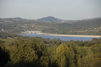 a bridge over a body of water with trees at Domek Tadeusz in Śleszowice Górne