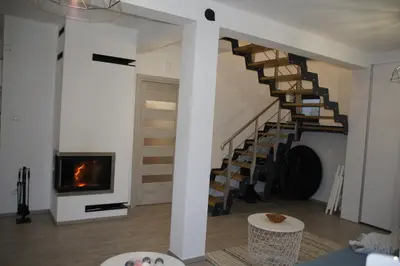 a living room with a staircase and a fireplace at Domek Tadeusz in Śleszowice Górne
