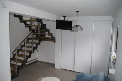 a staircase in a living room with a blue couch at Domek Tadeusz in Śleszowice Górne