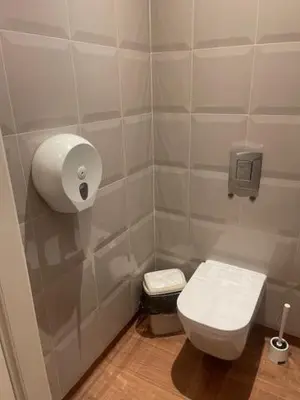 a bathroom with a toilet and a toilet paper dispenser at Hostel ALEX&TSA in Kraków