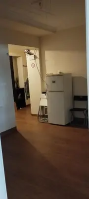 an empty room with a refrigerator and a chair at Hostel ALEX&TSA in Kraków